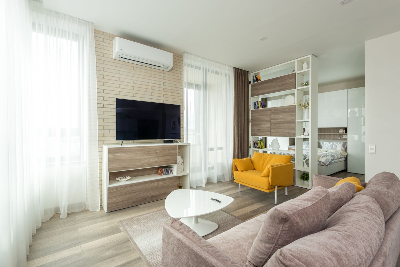 Open woonkamer met lichte wanden en een gele fauteuil