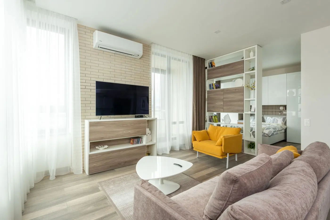 Open woonkamer met lichte wanden en een gele fauteuil